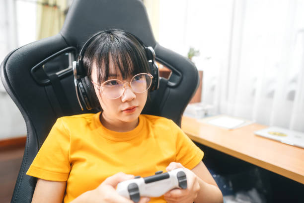 Young adult asian gamer woman wear eyeglasses play a online game. stock photo