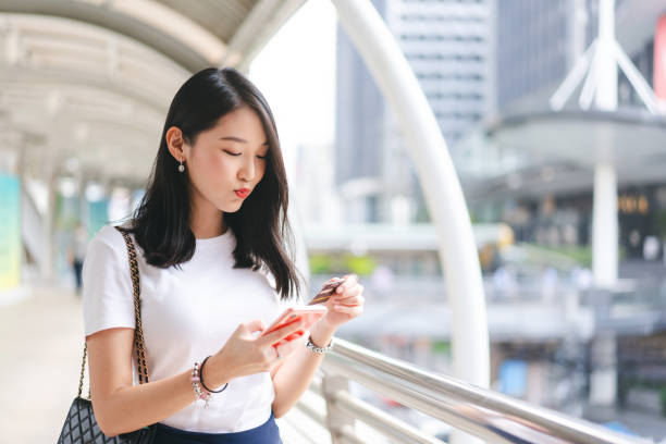 Young adult asian woman consumer using creadit card and smartphone. stock photo