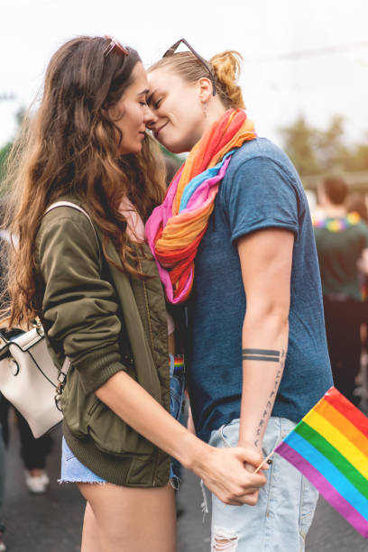 Young adult female couple  at pride parade stock photo