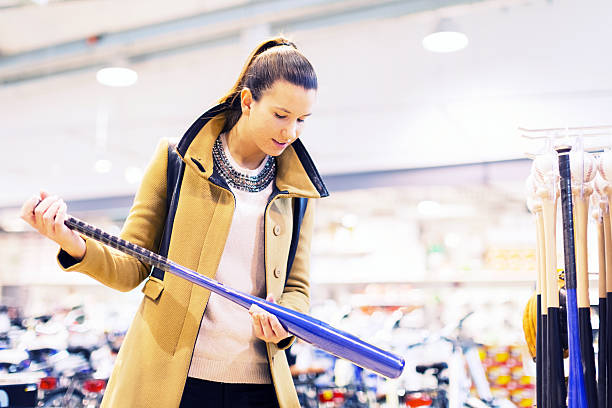 Young adult in store, buying baseball bat stock photo