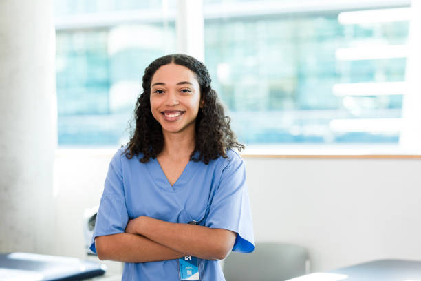 Young adult nursing student poses for photo with arms crossed A young adult female nursing student poses for a photo with her arms crossed. medical student stock pictures, royalty-free photos & images