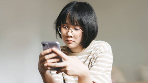 Young adult single woman using smartphone in the moring for online app mental health. stock photo
