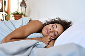 istock Young African American woman sleeping in modern bedroom with eyes closed. 1336961980