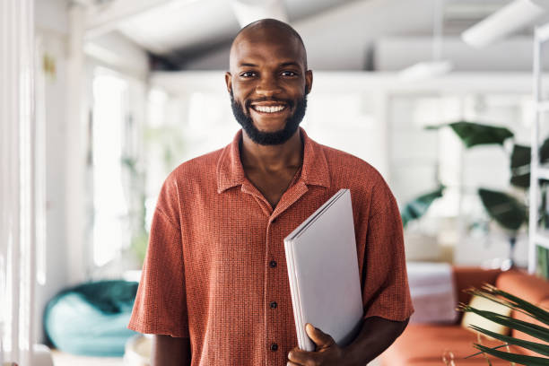 Young african businessman standing in an office at work stock photo