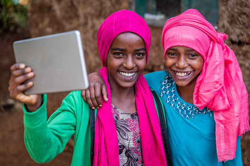 African girls using digital tablet in remote village in central Ethiopia, Africa.