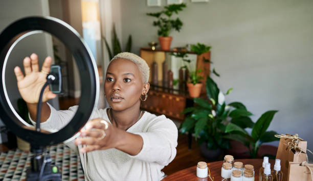 Young African influencer adjusting a ring light for her vlog post stock photo