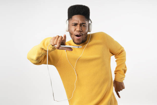 young african man using the mobile with headphones and dancing over isolated white background - dancer white man on white imagens e fotografias de stock