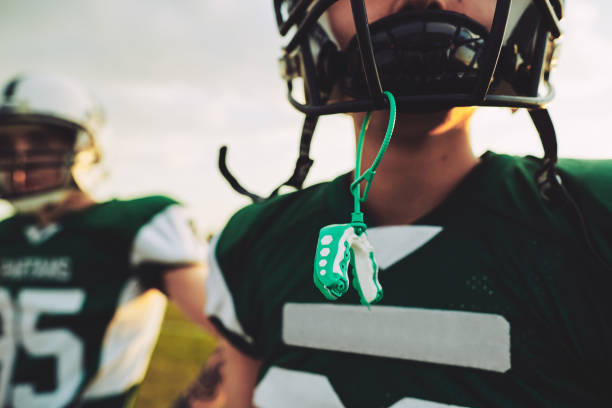 Young American football player with his mouthguard out during practice stock photo