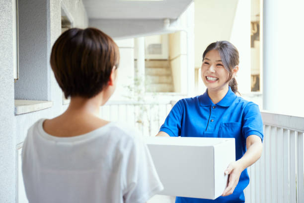 Young and cute Japanese woman delivering Young and cute Japanese woman delivering home delivery stock pictures, royalty-free photos & images