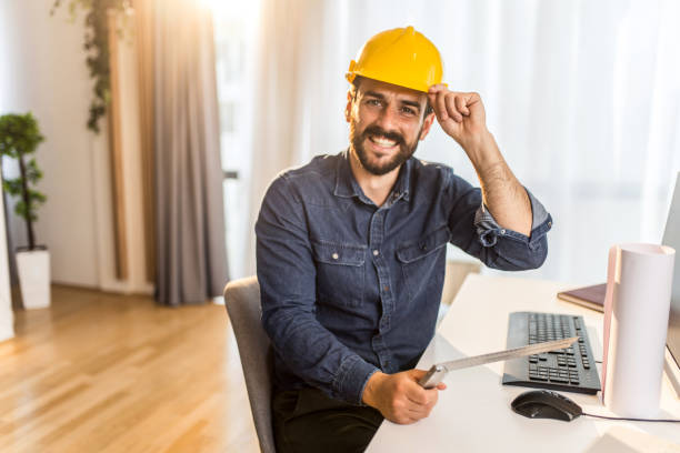 Young architect sitting at home office and looking at camera. stock photo