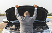 istock Young asian business has broken down car. He open hood and check the engine. He feeling upset and stressed. Car broken on the side of the road 1313758908