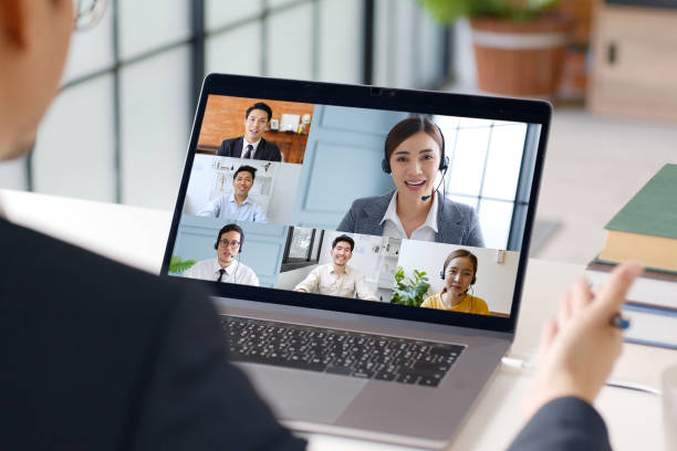 若いアジアのビジネスマンは、自宅で働き、同僚のビジネスの人々との仮想ビデオ会議、オンラインワーク、ホームオフィスでのビデオ通話 - オンライン会議 ストックフォトと画像