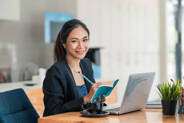 Young Asian businesswoman sitting at their desk and take notes using laptop in the office. Young Asian businesswoman sitting at their desk and take notes using laptop in the office. secretary stock pictures, royalty-free photos & images