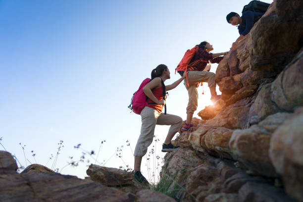 Young asian couple climbing up on the mountain,hiking and team work concept. Young asian couple climbing up on the mountain,hiking and team work concept. af_istocker stock pictures, royalty-free photos & images