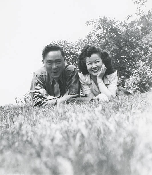 Young Asian Couple Laying in the Grass stock photo