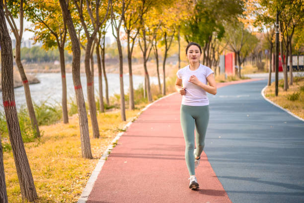 年輕的亞洲女性在城市公共公園跑步 - cardiovascular exercise 個照片及圖片檔