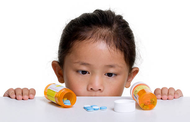A young Asian girl looking over a counter of open medicine stock photo