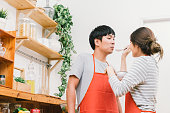 若いアジアの素敵なカップルは一緒に台所、食事を準備して料理を家で作ります。女の子は、ボーイ フレンドのスプーンを使ってスープを養います。結婚されていた人々 のライフ スタイル�