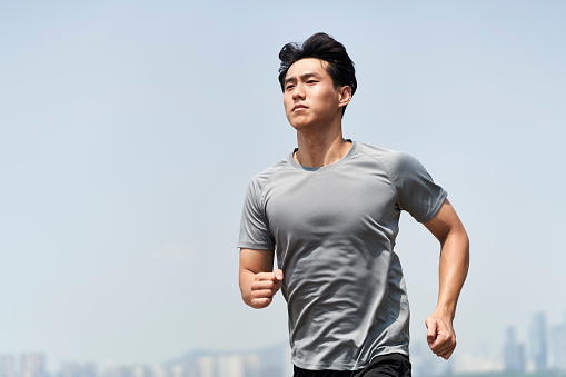 young asian man male runner jogger running jogging outdoors