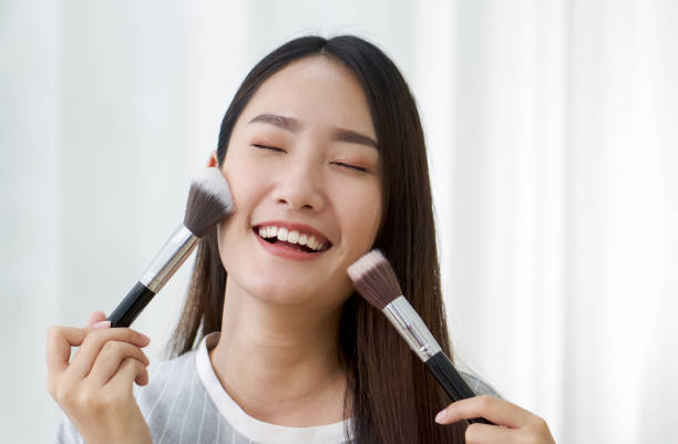 Young asian teen have fun learning to make-up in her room, enjoy leisure weekend at home. Close up stock photo
