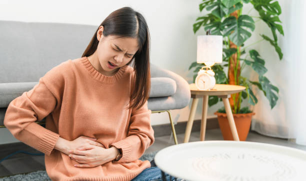 Young Asian woman hands holding the stomach and pain period cramps because having menstruation Young Asian woman hands holding the stomach and pain period cramps because having menstruation stomachache photos stock pictures, royalty-free photos & images