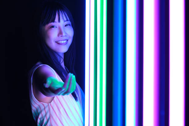 Young asian woman pose with colorful bright neon lights in studio. stock photo