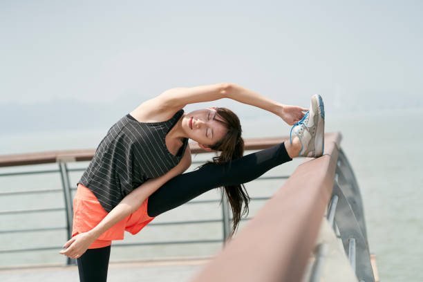 young asian woman warming up preparing for exercise stock photo
