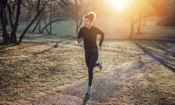 Young athlete exercise at the park. Young woman running at the park stock photo