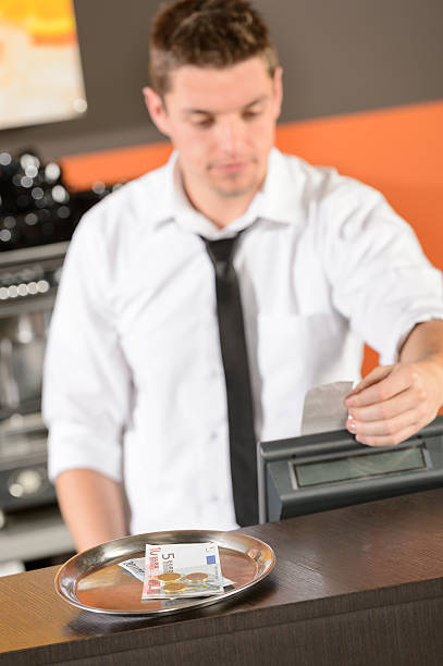 Young bartender in uniform taking cash euro stock photo