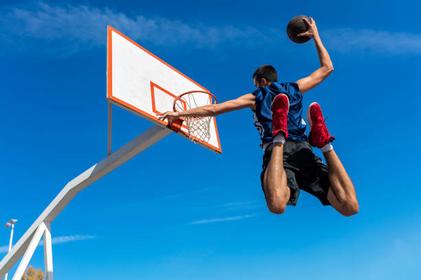jonge straat basketballer maken slam dunk - basketball player back stockfoto's en -beelden