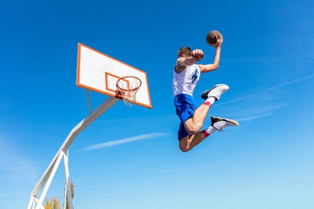jonge straat basketballer maken slam dunk - basketball player back stockfoto's en -beelden