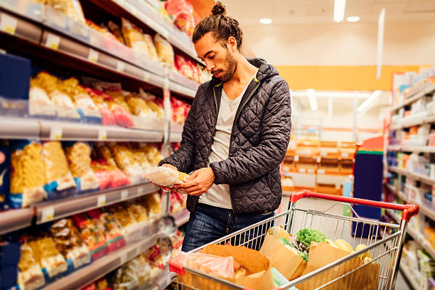 young bearded man in a supermarket. - food labels bildbanksfoton och bilder