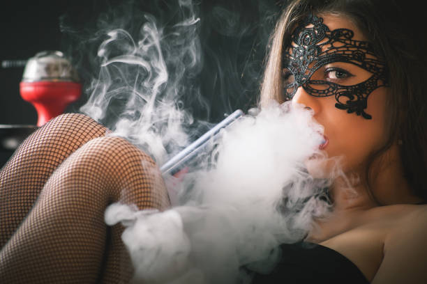 Young, beautiful girl smoke a hookah at club stock photo