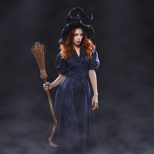 Young beautiful red-haired witch in the dark fog Young beautiful red-haired witch with a broom in the dark fog ugly skinny women stock pictures, royalty-free photos & images