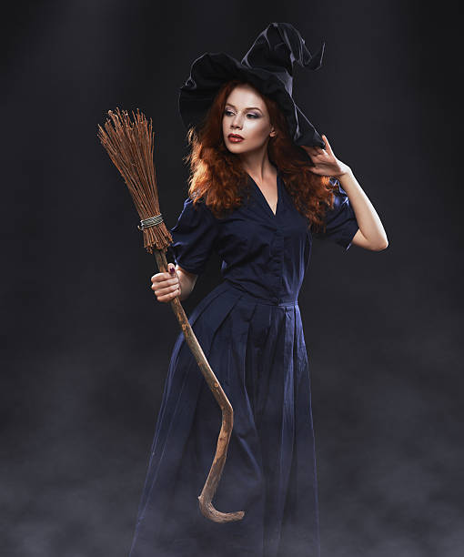 Young beautiful red-haired witch in the dark fog Young beautiful red-haired witch with a broom in the dark fog ugly skinny women stock pictures, royalty-free photos & images