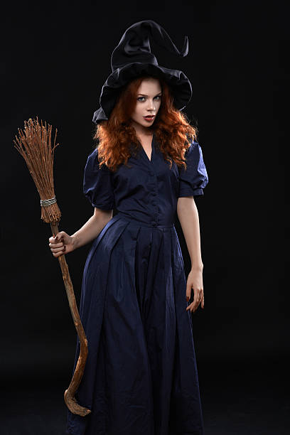 Young beautiful red-haired witch in the dark Young beautiful red-haired witch with a broom in the dark ugly skinny women stock pictures, royalty-free photos & images