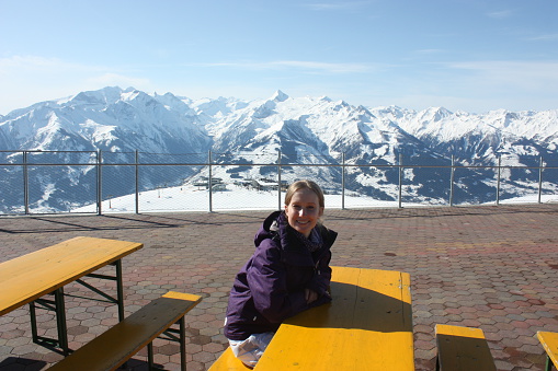 Young beautiful snowboarder woman sitting on the table.