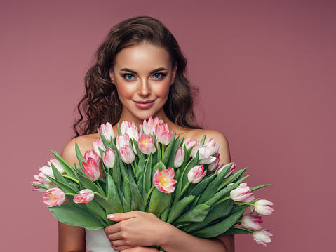 Young beautiful woman holding a bouquet of flowers