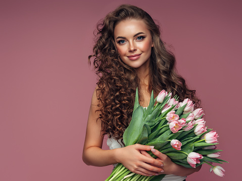 Young beautiful woman holding a bouquet of flowers