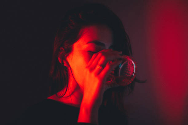 Young Beautiful Women Drinking Red Light Portrait stock photo