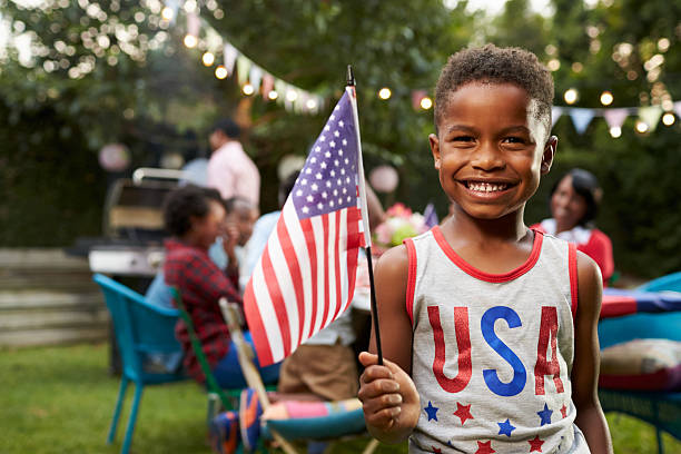 7월 4일 가족 정원에서 깃발을 들고 있는 어린 흑인 소년 - independence day 뉴스 사진 이미지