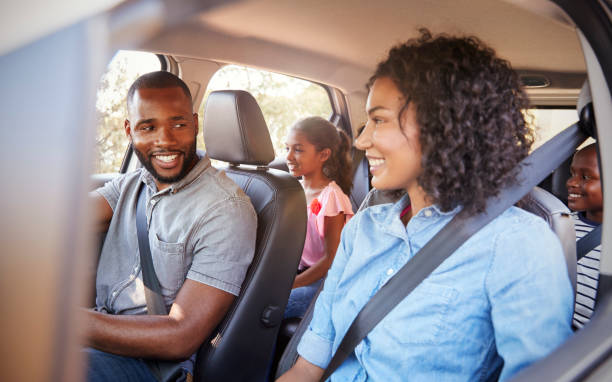 young black family in a car on a road trip smiling - family car imagens e fotografias de stock
