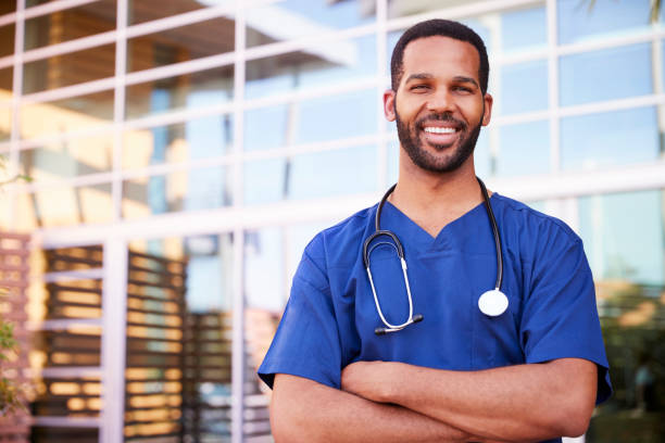 Young black male healthcare worker smiling outside, portrait Young black male healthcare worker smiling outside, portrait males stock pictures, royalty-free photos & images
