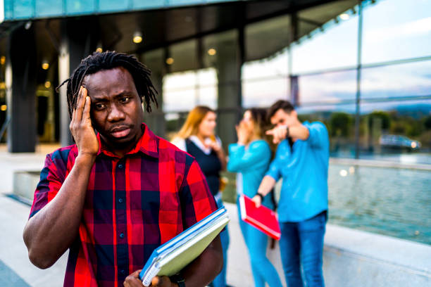 Young black man rejected by a group stock photo