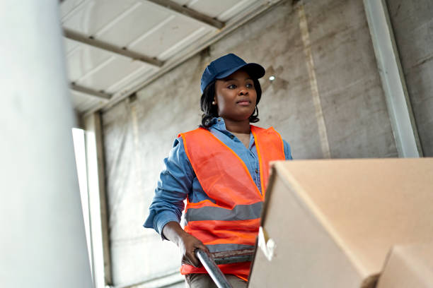 Young Black Woman Loading Boxes with Hand Truck stock photo