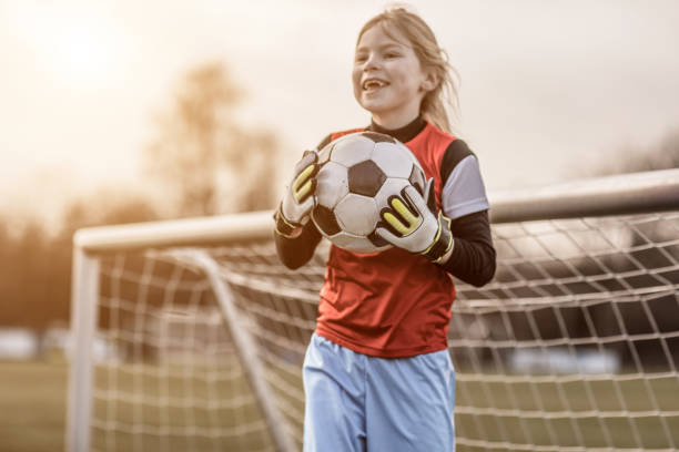 Young Blonde Female Soccer Goalkeeper Girl during football training Young Blonde Female Soccer Goalkeeper Girl during football training goalie stock pictures, royalty-free photos & images
