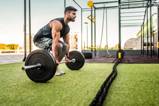 Young bodybuilder doing a deadlift at the outdoor gym. stock photo