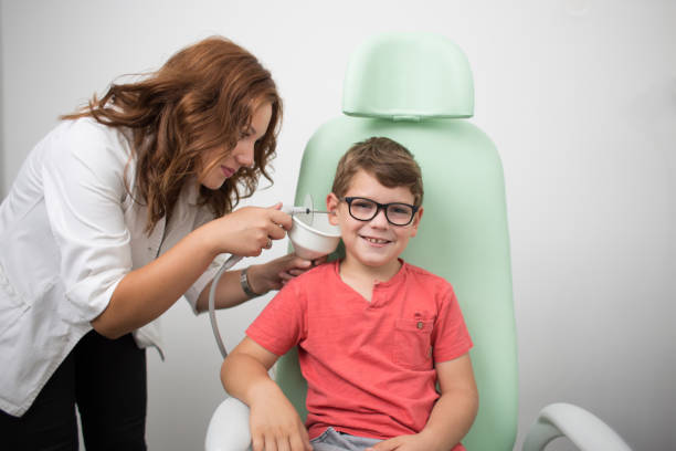 Young boy at medical examination or checkup in otolaryngologist's office. stock photo