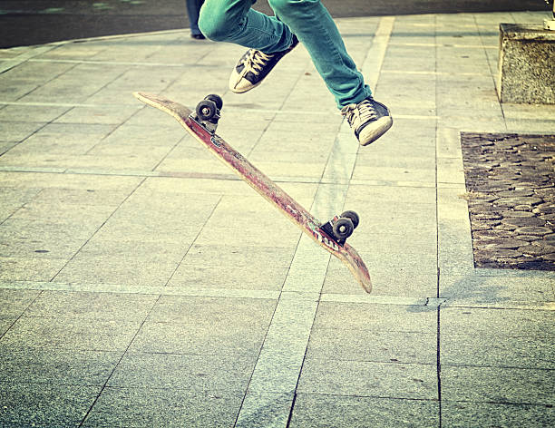 Young boy doing tricks on skateboard. stock photo