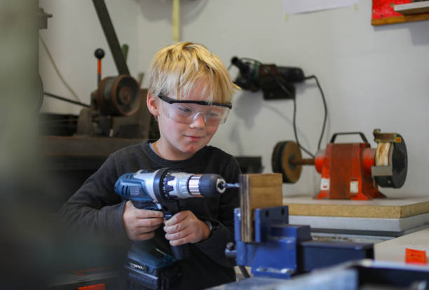 A young boy working with carpentry tools stock photo
